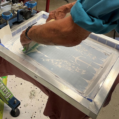 Person screenprinting a t-shirt